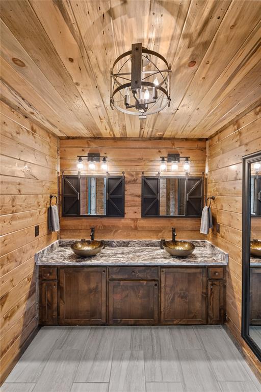 bathroom with wooden walls, hardwood / wood-style floors, vanity, and wooden ceiling