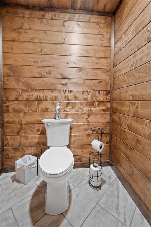 bathroom with toilet, wood ceiling, and wood walls