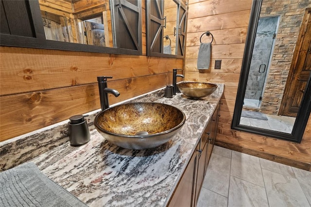 interior details featuring wood walls, vanity, and a shower with shower door