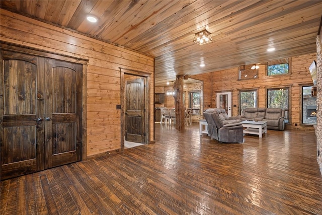 unfurnished living room with a fireplace, dark hardwood / wood-style floors, wood walls, and wood ceiling