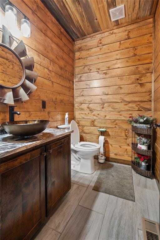 bathroom featuring hardwood / wood-style floors, wood walls, toilet, and wood ceiling