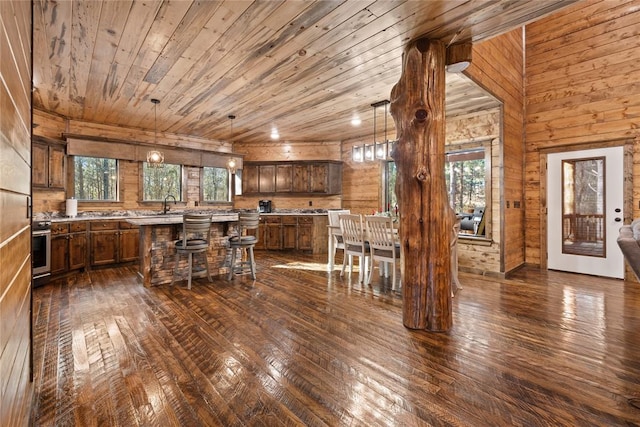 kitchen featuring a center island, plenty of natural light, dark hardwood / wood-style floors, and wood walls