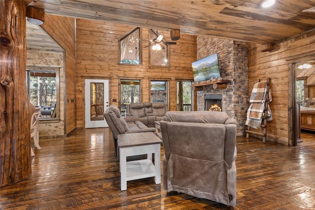 living room with a wealth of natural light, a towering ceiling, and dark hardwood / wood-style floors