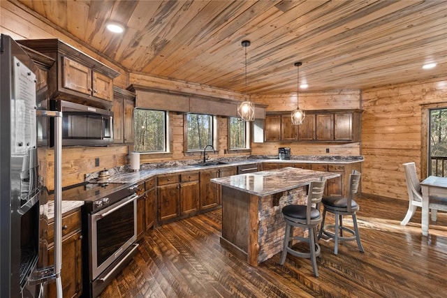 kitchen featuring a wealth of natural light, a center island, lofted ceiling, and appliances with stainless steel finishes