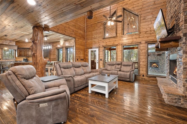 living room featuring ceiling fan, wooden walls, dark wood-type flooring, high vaulted ceiling, and a fireplace