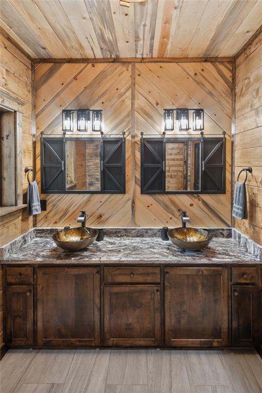 bathroom featuring wooden walls, vanity, and wooden ceiling