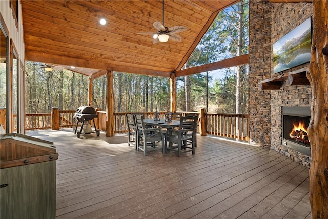 exterior space with an outdoor stone fireplace, ceiling fan, wood ceiling, and vaulted ceiling