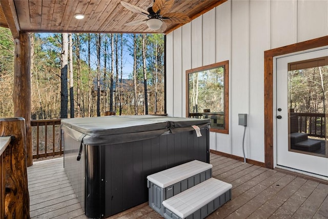 wooden deck with ceiling fan and a hot tub