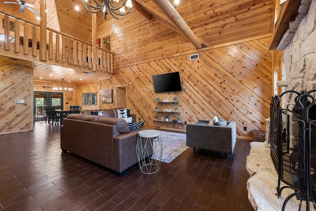 living room featuring dark hardwood / wood-style flooring, beam ceiling, high vaulted ceiling, a notable chandelier, and wood walls