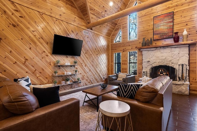 living room with high vaulted ceiling, a stone fireplace, wooden walls, hardwood / wood-style flooring, and beam ceiling