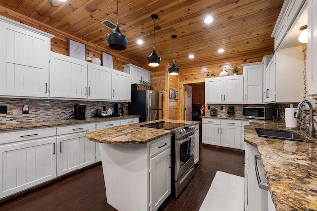 kitchen with a center island, white cabinets, dark hardwood / wood-style floors, decorative light fixtures, and stainless steel appliances