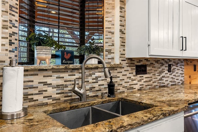 kitchen with stone counters, sink, stainless steel dishwasher, decorative backsplash, and white cabinetry