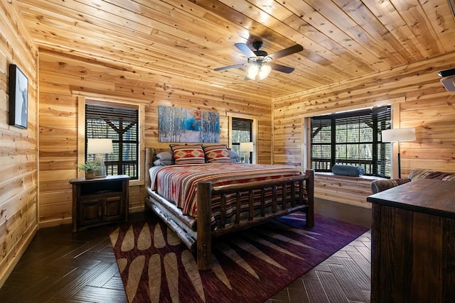 bedroom with ceiling fan, wood walls, wood ceiling, and dark parquet floors