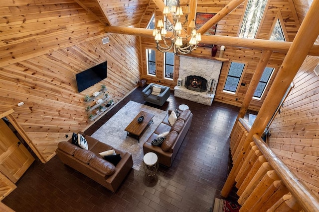 living room featuring plenty of natural light, wood walls, and a chandelier