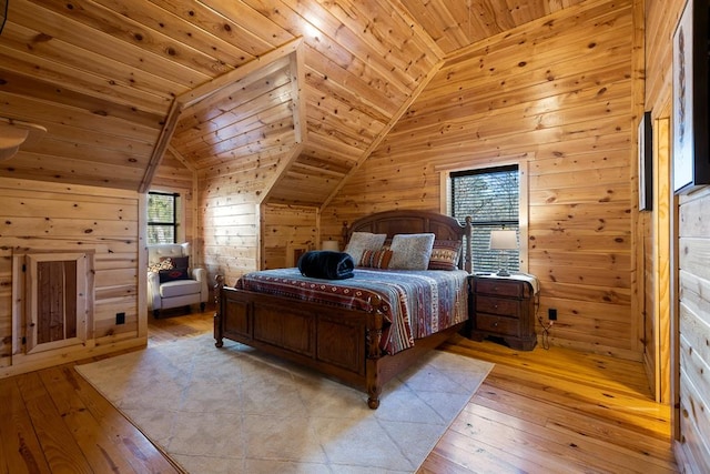 bedroom with lofted ceiling, wood walls, light wood-type flooring, and wood ceiling