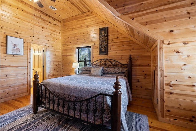 bedroom featuring wooden ceiling, wooden walls, vaulted ceiling, hardwood / wood-style flooring, and ceiling fan