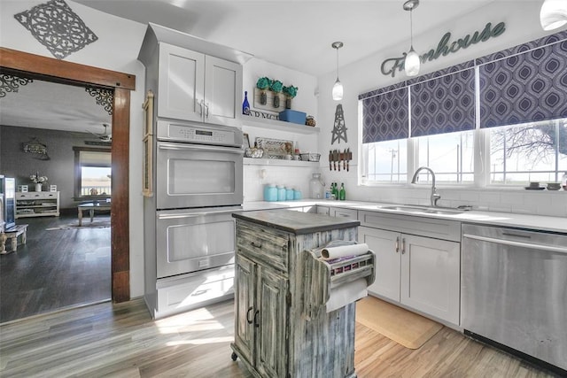 kitchen with appliances with stainless steel finishes, light hardwood / wood-style floors, a healthy amount of sunlight, and sink