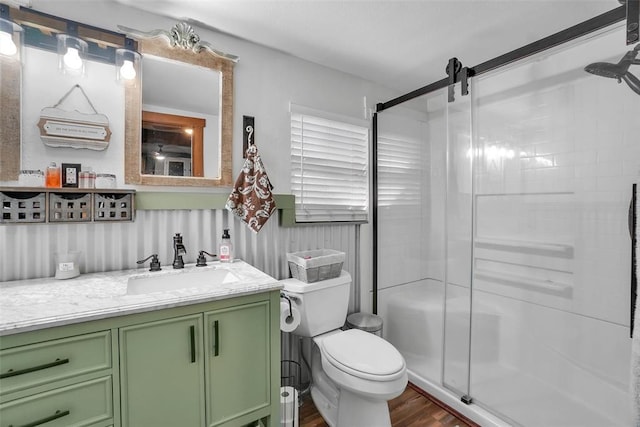 bathroom featuring toilet, vanity, hardwood / wood-style floors, and walk in shower