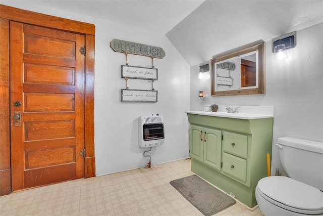 bathroom with vanity, vaulted ceiling, toilet, and heating unit