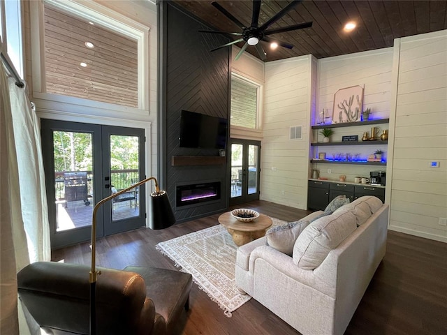 living room with french doors, wooden ceiling, dark hardwood / wood-style flooring, high vaulted ceiling, and a fireplace