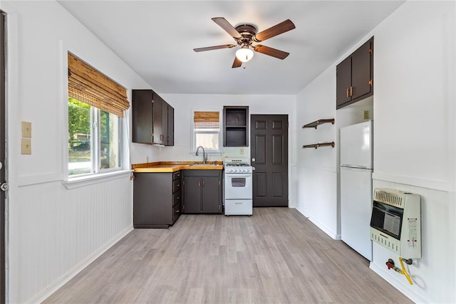 kitchen with sink, heating unit, light hardwood / wood-style floors, white appliances, and dark brown cabinets