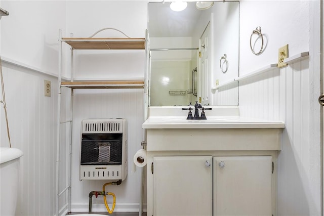 bathroom with vanity, heating unit, and toilet