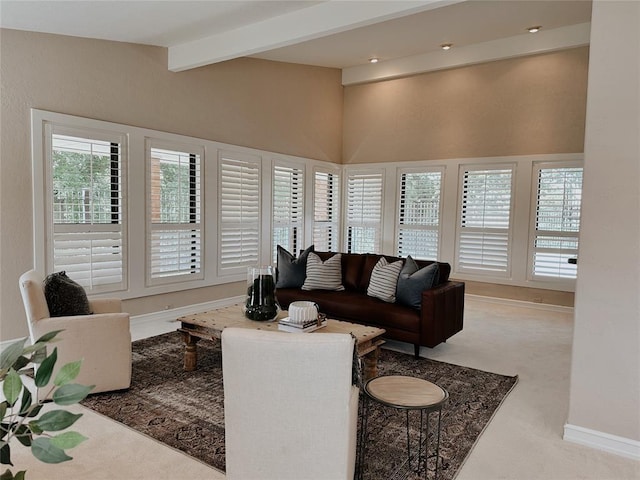 carpeted living room featuring beamed ceiling and a towering ceiling