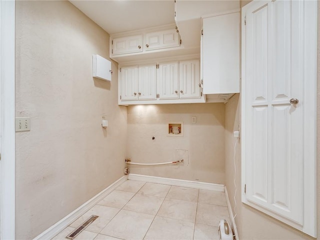 laundry room featuring gas dryer hookup, cabinets, washer hookup, and light tile patterned floors