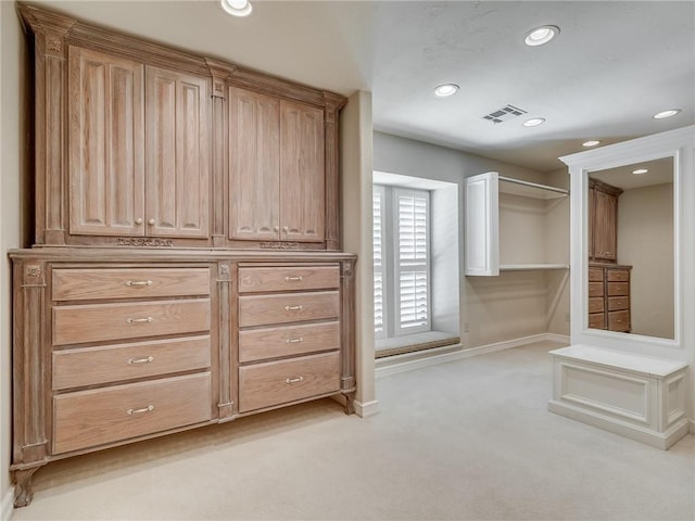 walk in closet featuring light colored carpet