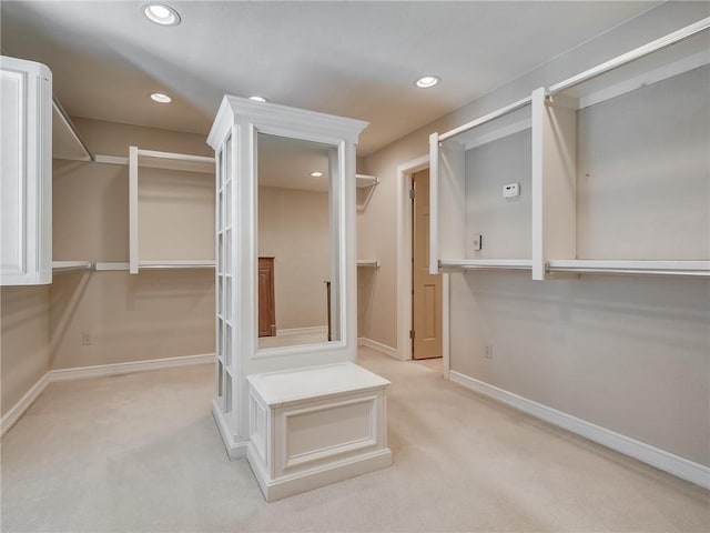 walk in closet featuring light carpet