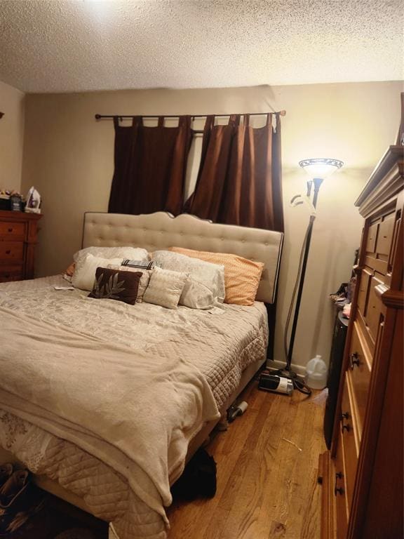 bedroom featuring light wood-type flooring and a textured ceiling