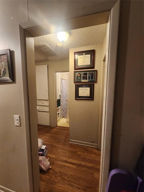 hall featuring a textured ceiling and hardwood / wood-style flooring