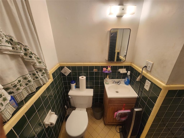 bathroom featuring vanity, toilet, and tile walls