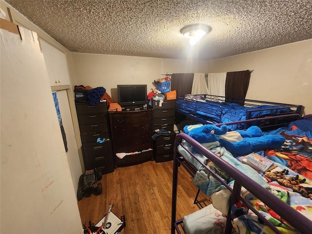 bedroom with a textured ceiling and hardwood / wood-style flooring