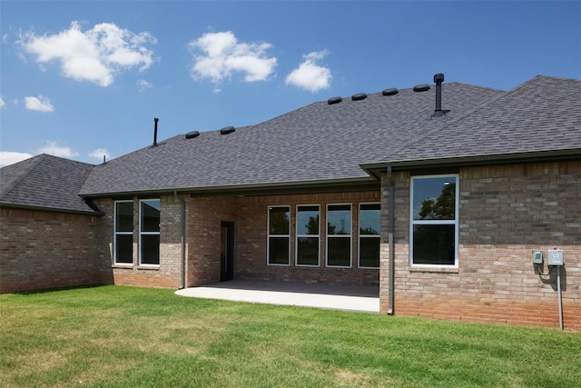 back of property featuring a lawn and a patio area