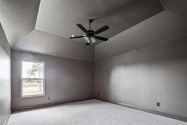 carpeted spare room with a textured ceiling, ceiling fan, and lofted ceiling