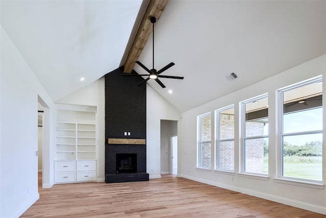 unfurnished living room with ceiling fan, light hardwood / wood-style flooring, high vaulted ceiling, beamed ceiling, and a fireplace