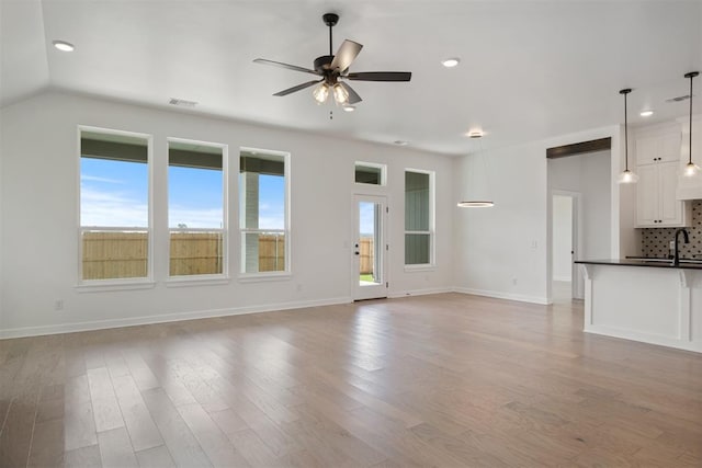 unfurnished living room with ceiling fan and light hardwood / wood-style floors