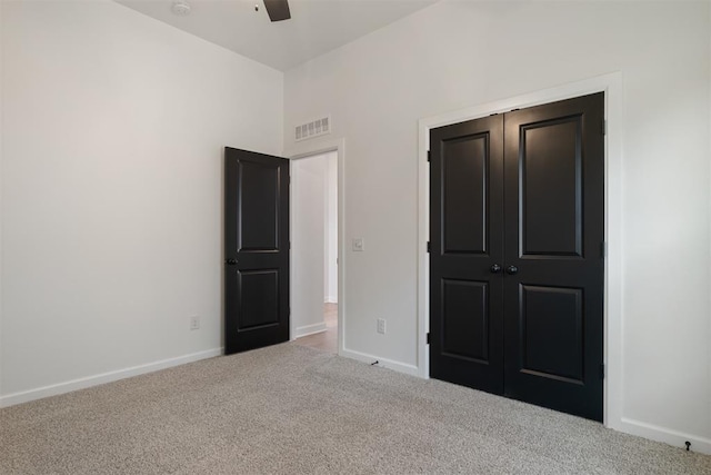 unfurnished bedroom with carpet, a closet, and ceiling fan