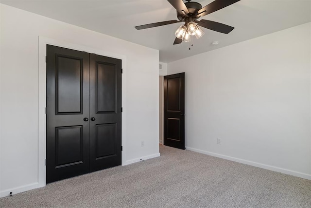 unfurnished bedroom with ceiling fan, light colored carpet, and a closet