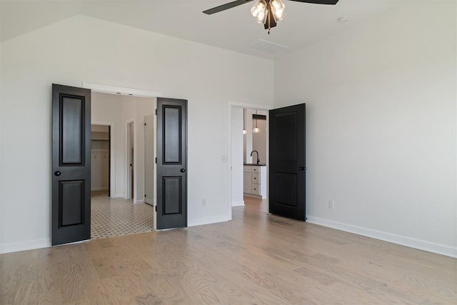 unfurnished bedroom featuring high vaulted ceiling, light hardwood / wood-style flooring, ceiling fan, and sink