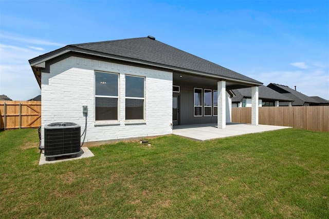 rear view of property with a yard, central AC, and a patio area