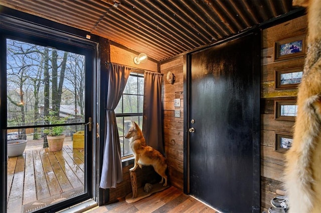 doorway to outside with wooden ceiling, lofted ceiling, hardwood / wood-style flooring, and wooden walls