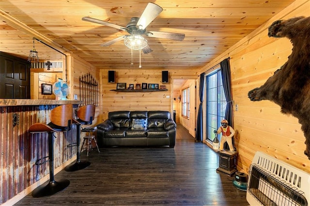 living room featuring heating unit, wooden walls, wooden ceiling, and dark hardwood / wood-style floors