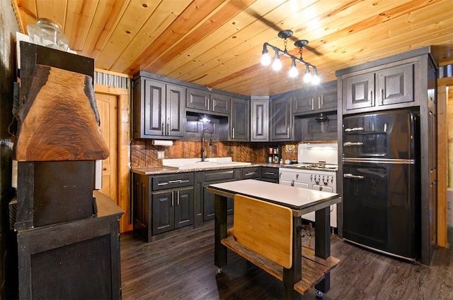 kitchen with black refrigerator, pendant lighting, wood ceiling, and sink