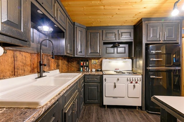 kitchen with sink, dark wood-type flooring, white range with gas stovetop, backsplash, and dark brown cabinets