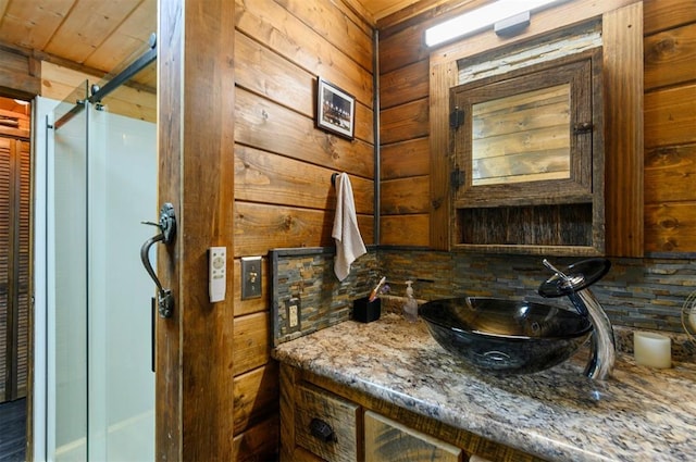 bathroom with vanity, backsplash, walk in shower, and wood walls