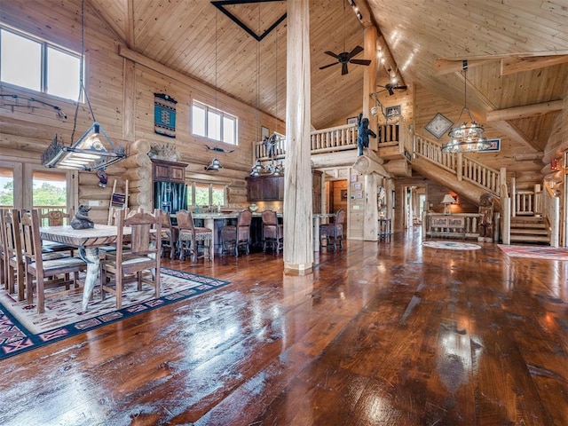 unfurnished dining area featuring ceiling fan, hardwood / wood-style flooring, wood ceiling, log walls, and high vaulted ceiling