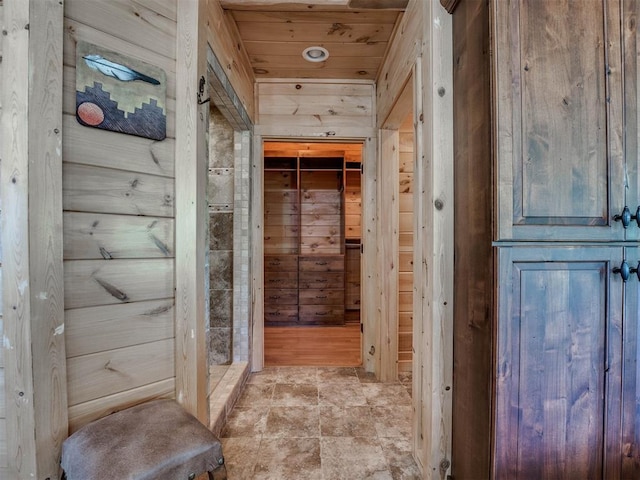 hall featuring wooden ceiling and wood walls