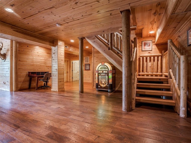 unfurnished living room with wooden ceiling, hardwood / wood-style floors, and wooden walls